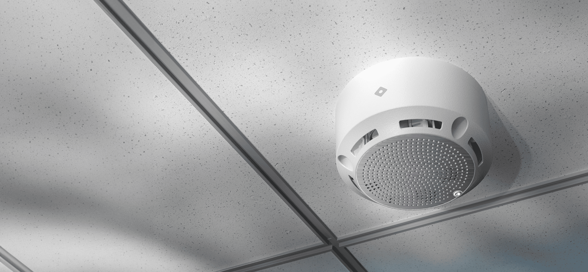 Rhombus E50 environmental sensor mounted in a school restroom is shown detecting vape clouds. The sensor's multiple environmental monitoring capabilities, including humidity sensors and temperature sensors, are highlighted as it measures relative humidity, ambient temperature, and air quality. The device showcases its ability to accurately assess environmental factors and provide crucial data for maintaining environmental health in educational settings.