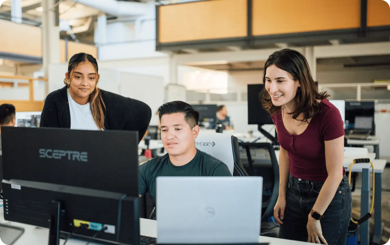 Three Rhombus employees at a computer