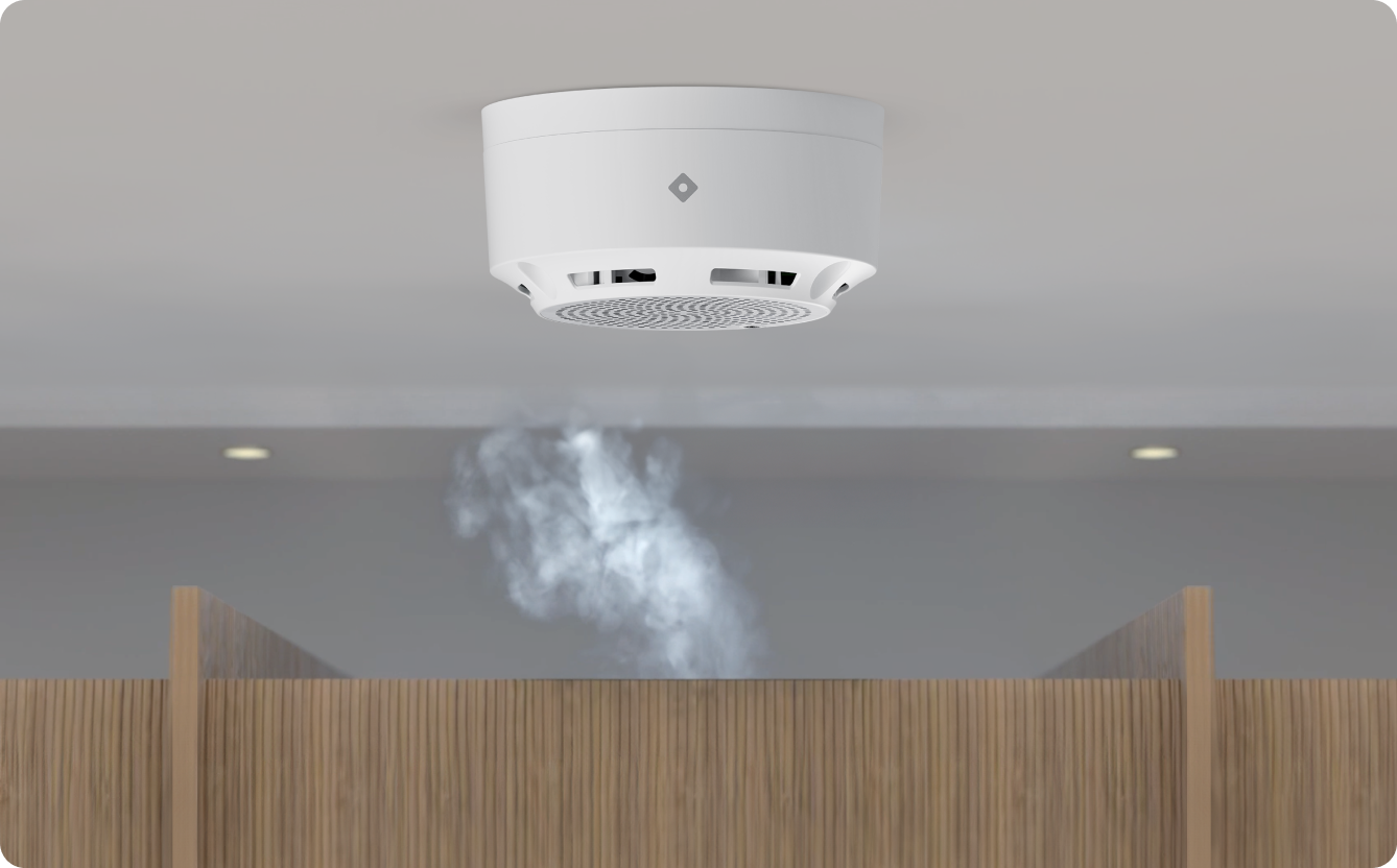 An environmental sensor is installed in a college or a school restroom, actively detecting vape emissions. The device is designed to monitor air quality and identify harmful chemicals associated with vaping, contributing to a safer environment for students. The visible presence of the sensor serves as a deterrent against vaping in this private space.