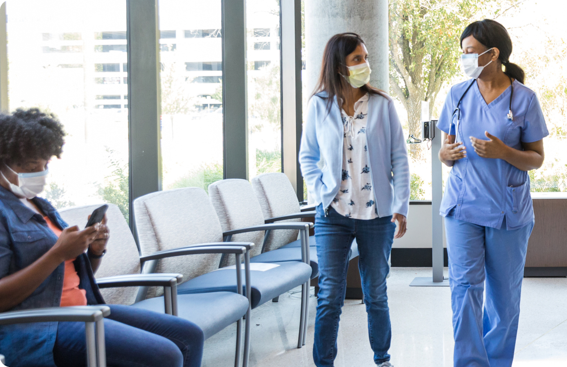 A healthcare worker and a patient walking from the waiting room
