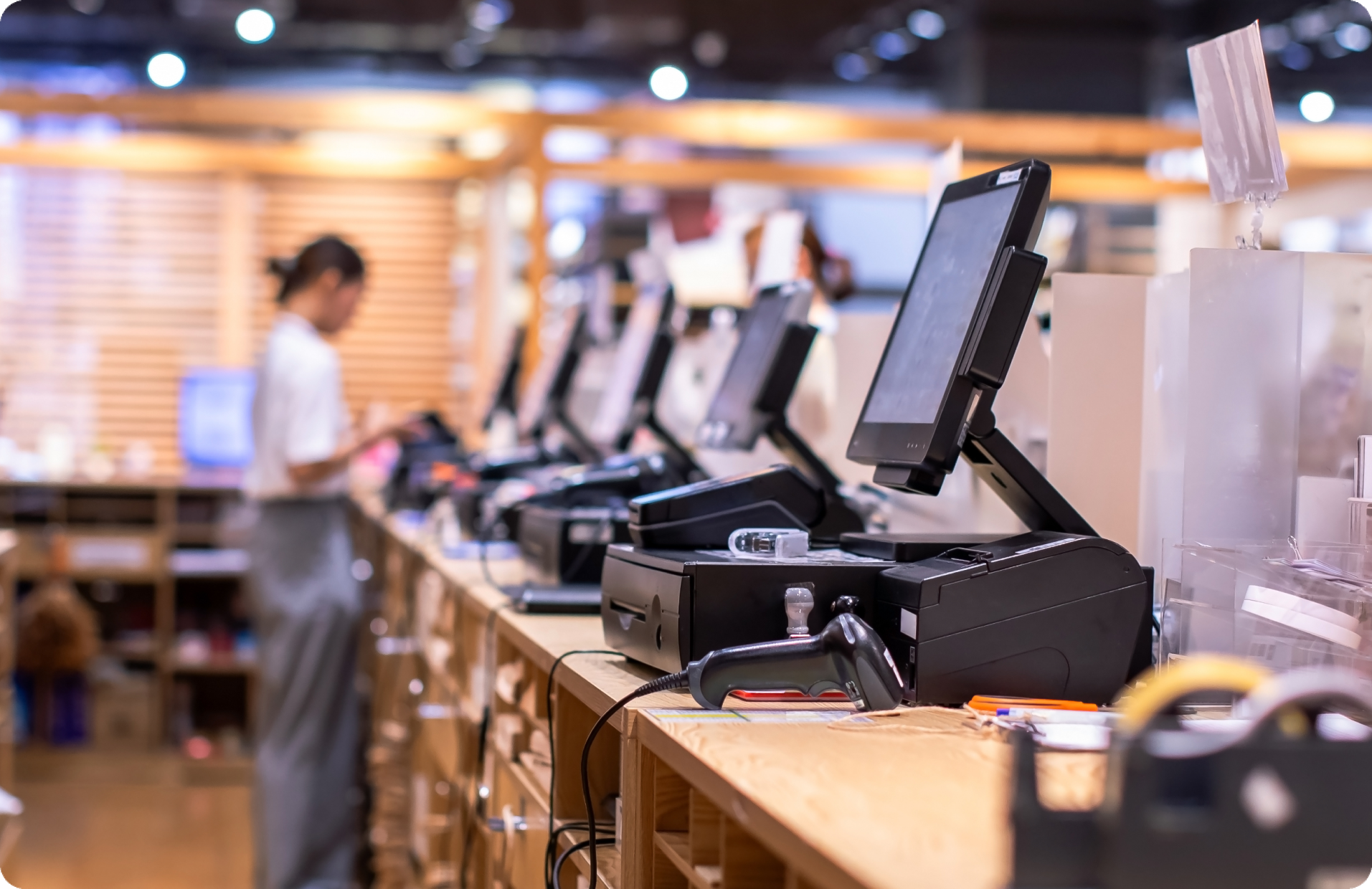 A retail worker standing by POS machines