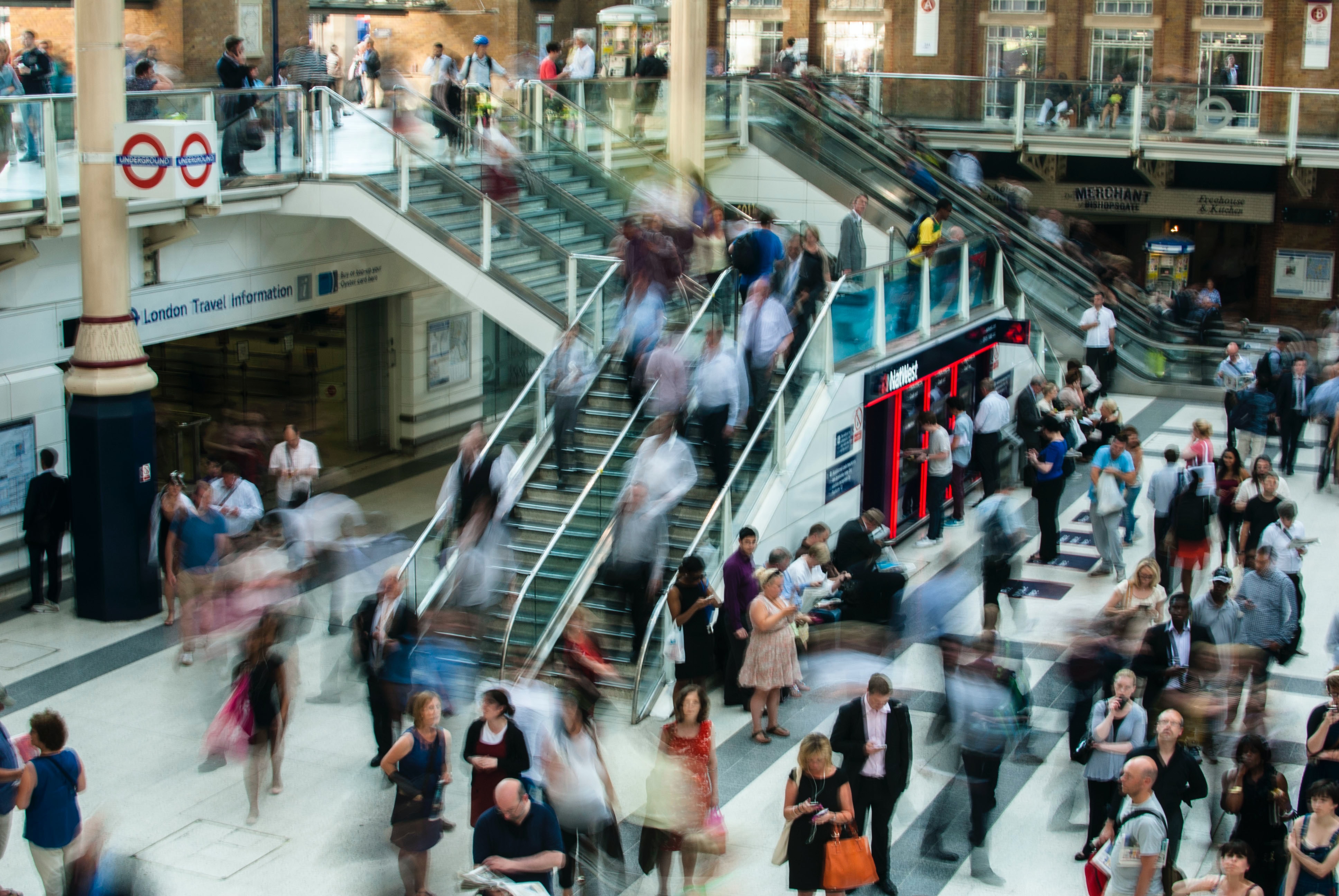 Time-lapse busy mall Time-lapse of busy mall showing blurred pedestrians using escalators and stairs.