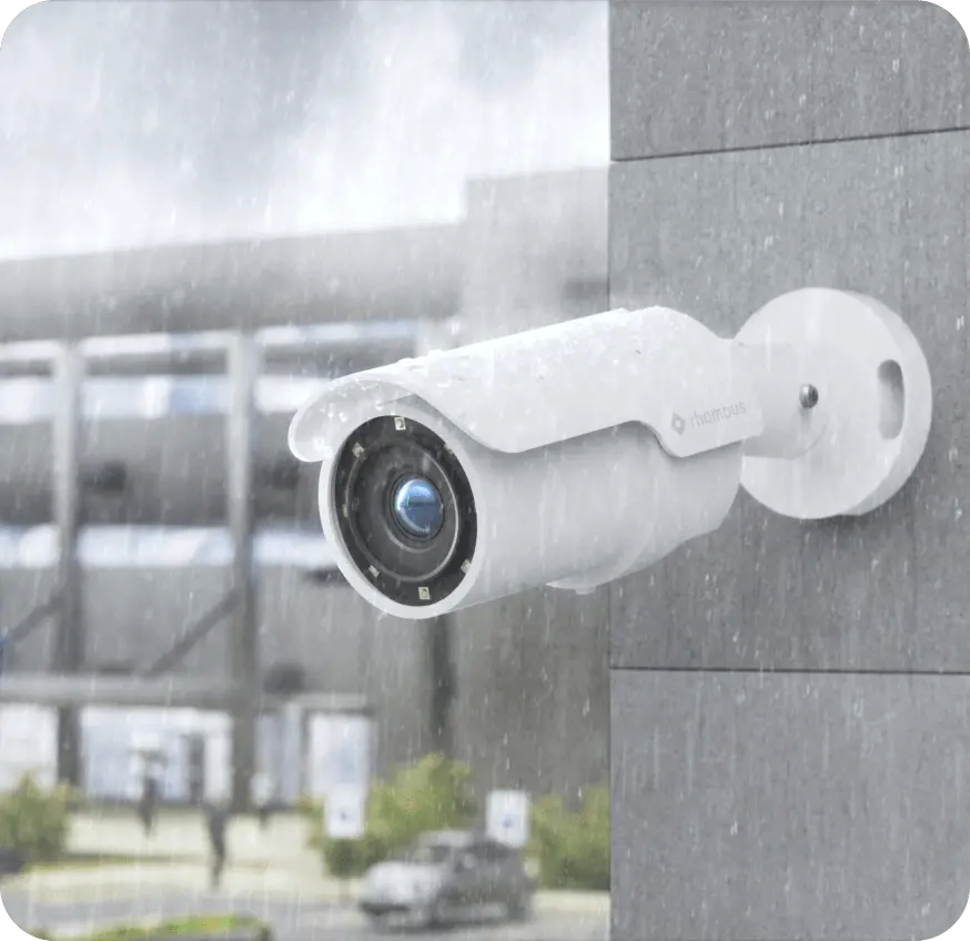 Outdoor bullet security camera in rain, showcasing weatherproof housing as one of its key benefits. Not all bullet cameras have such casing. It delivers long-range detail and night vision for high-quality video footage.