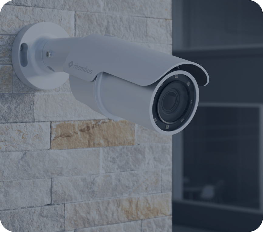 The R510 bullet surveillance camera, which has a wide angle lens compared to the R500, is mounted outside an office. It is known for long-range coverage and detailed image quality in outdoor settings.