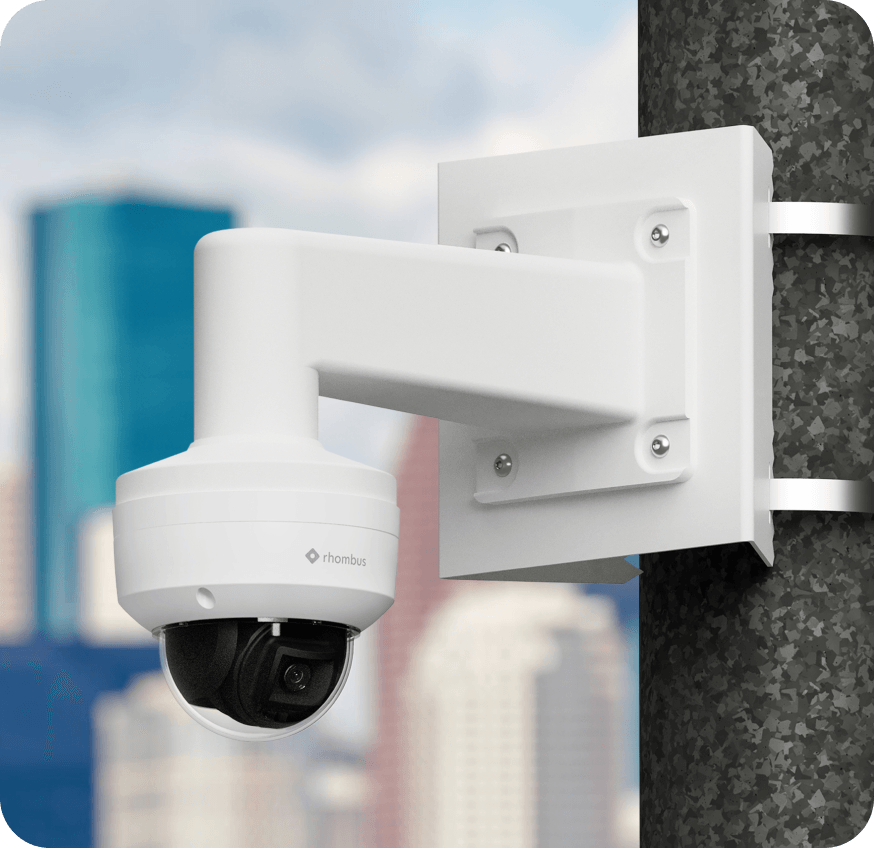 Vandal-proof dome camera mounted on a building corner using an L-shaped bracket, ideal for surveillance in high-traffic areas with its discreet and durable design.